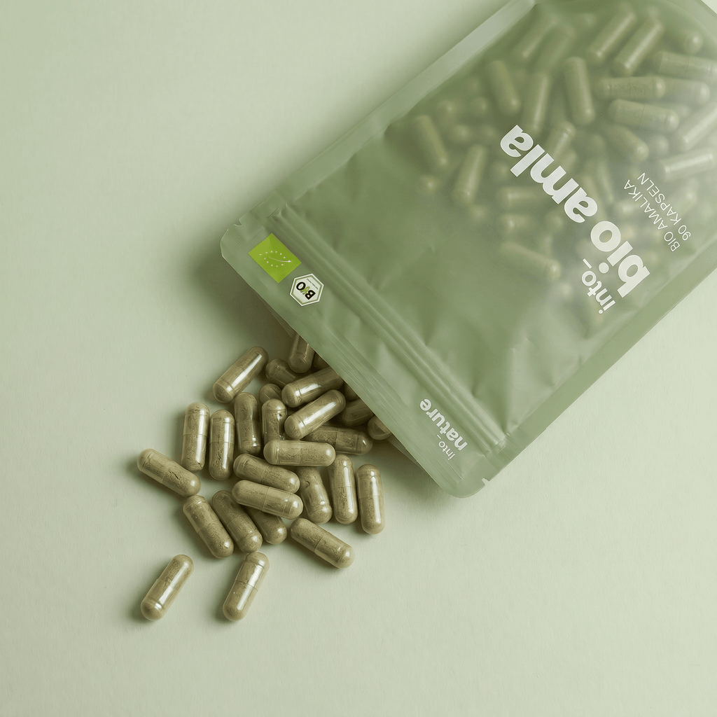 Geöffnete Verpackung mit herausfallenden veganen Bio Amla Kapseln