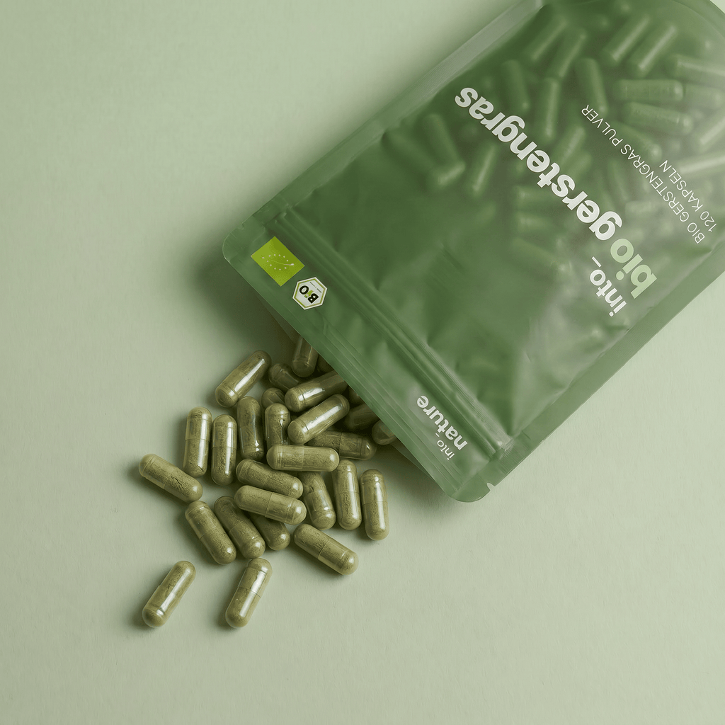 Geöffnete Verpackung mit herausfallenden Bio Gerstengras Kapseln