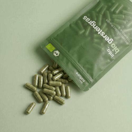 Geöffnete Verpackung mit herausfallenden Bio Gerstengras Kapseln