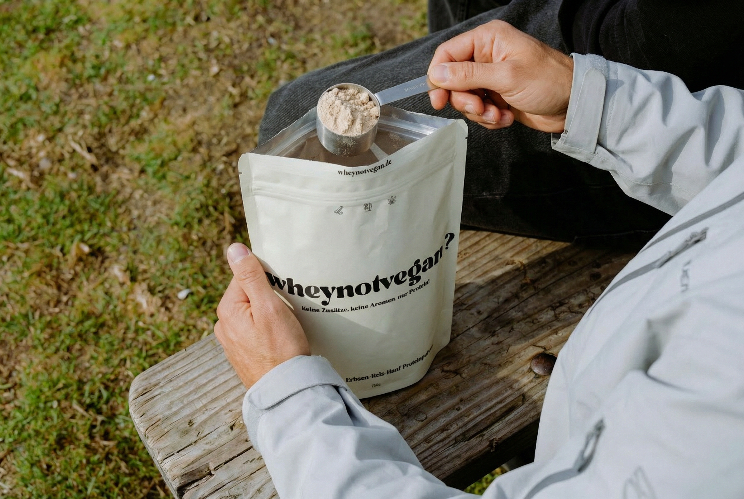 Veganes Bio-Proteinpulver wird mit einem Messlöffel aus der Packung entnommen