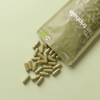 Geöffnete Verpackung mit herausfallenden veganen Bio Triphala Kapseln